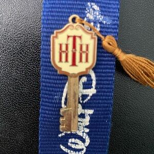 Disney The Hotel of Horrors collectible pin, gold with red monogram lettering.